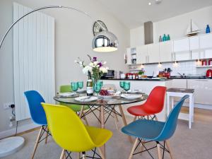 een eetkamer met een tafel en kleurrijke stoelen bij Sunset Bay - 31 Horizon View in Westward Ho +13 foto's