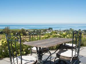 une table et des chaises avec vue sur l'océan dans l'établissement Ty Gan Y Mor, à Nefyn
