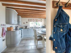 une cuisine avec une veste en jean accrochée au mur dans l'établissement Ty Gan Y Mor, à Nefyn