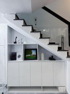 ein Wohnzimmer mit einem TV unter einer Treppe in der Unterkunft Kem Homestay - Nhà riêng 2 phòng ngủ in Haiphong