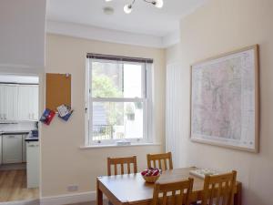 ein Esszimmer mit einem Tisch und einem Fenster in der Unterkunft Millie's Cottage in Keswick