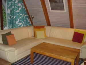a white couch with colorful pillows on a porch at Norddachhaus in Damp