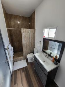 a bathroom with a shower and a sink and a toilet at Hotel Cuatro Palmas in Puerto Peñasco