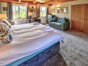 a large white bed in a room with a couch at Hadrians Garden Villa in Bardon Mill +23 photos