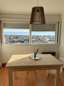 a wooden table in a room with a large window at Departamento Impecable Luminoso! in Azul