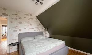 een slaapkamer met een bed en een groene muur bij Ferienwohnung Gretl Seeblick in Sassnitz