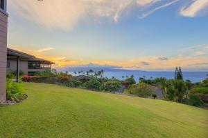 a house with a lawn in front of the ocean at 412 Ridge in Kahana
