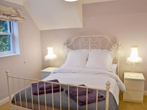 une chambre avec un lit blanc et deux lampes dans l'établissement Tower Cottage - Mvw, à Belsay