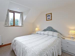 une chambre blanche avec un lit et une fenêtre dans l'établissement Coot Cottage, à Dilham
