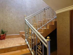 a staircase with a metal handrail and wooden stairs at Cape Villa in Arusha