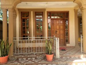a front porch of a house with potted plants at Cape Villa in Arusha