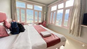 a bedroom with a bed with a backpack on it at Hotel Sunrise Meadows Mountain in Manāli
