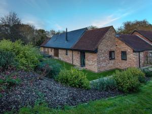 een oud bakstenen huis met een tuin ervoor bij Willow Barn - Fernhill Farm in Wootton Bridge