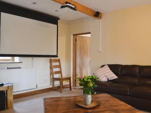a living room with a couch and a large screen at Celyn in Montgomery