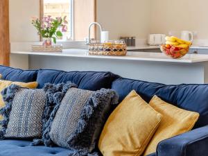un sofá azul con almohadas en la cocina en Dip Tub Den - Uk35989, en Wansford