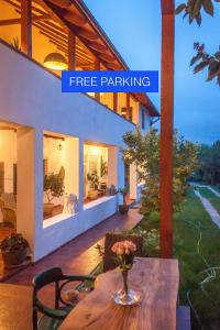 een huis met een tafel met daarop een vaas met bloemen bij Elma Guesthouse in Alba Iulia