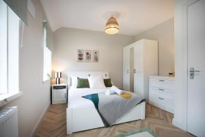 una camera da letto con un letto bianco e un armadio bianco di 4 Bed Contractor Accommodation in Longbridge a Longbridge