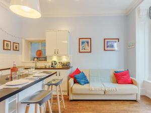 a living room with a couch and a kitchen at Viking Bay Apartment in Broadstairs