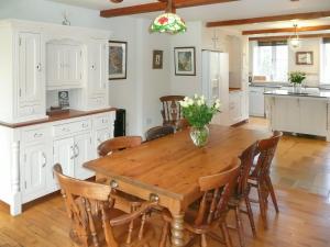 een keuken en eetkamer met een houten tafel en stoelen bij Dove Cote House in Westleigh