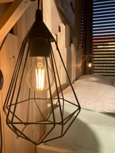 a lamp hanging from a wall next to a bed at Bnb Pavillon Paisible in Orsonnens
