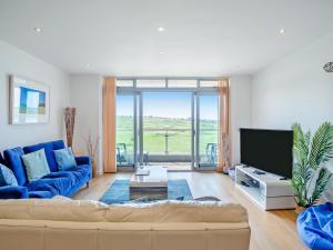 a living room with a blue couch and a tv at 7 Cribbar in Newquay