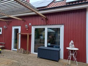 Un edificio rojo con una mesa en un patio. en Önnestad guest house, en Önnestad