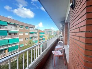 a balcony with a pink chair and some buildings at Rooms Borrells in Barcelona