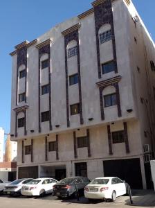 a building with cars parked in front of it at Al Madinah Hotel in Al Madinah