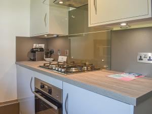 a kitchen with a stove and a counter top at Upper Sycamore Cottage in Ambleside