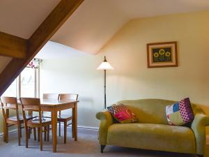 a living room with a couch and a table at Upper Sycamore Cottage in Ambleside