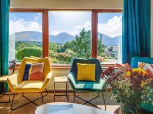 Dos sillas y una mesa frente a un gran ventanal. en Beech House, en Torcastle