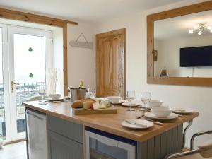 Una cocina con una mesa con platos y copas de vino. en Making Waves, en Anstruther