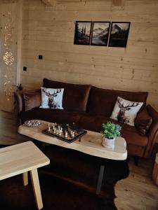 a living room with a couch and chessboard on a table at Domek z Sercem in Pieniążkowice