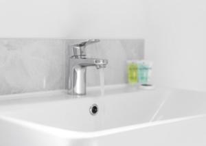 een wastafel met een kraan in de badkamer bij Stylish 2 Bed Apartment - Smart TV - WiFi - Parking 27C in Sleightholme