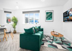 een woonkamer met een groene bank en een tafel bij Stylish 2 Bed Apartment - Smart TV - WiFi - Parking 27C in Sleightholme