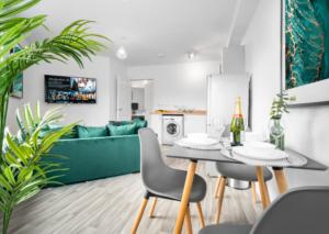 een woonkamer met een tafel, stoelen en een bank bij Stylish 2 Bed Apartment - Smart TV - WiFi - Parking 27C in Sleightholme
