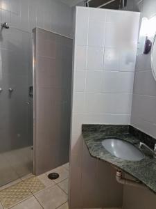 a bathroom with a sink and a shower at Motel Marajas Mococa - Apartamento 23 in Mococa