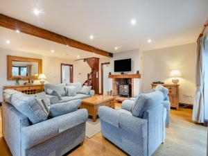 SculthorpeにあるWoodpecker Barn - Cwlの2つのソファと暖炉のあるリビングルーム