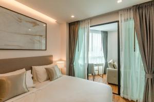 Ένα ή περισσότερα κρεβάτια σε δωμάτιο στο The Proud Rawai Resort