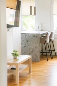 a living room with a table and a counter at Apartamentai Akvilė in Šilutė