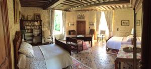 Un dormitorio con una cama y un escritorio. en Le Château d'Asnières en Bessin, en Asnières-en-Bessin