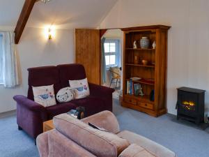 a living room with a couch and a fireplace at Myrtle Loft in Instow
