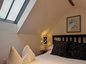 un dormitorio con una cama y una ventana en Blue Charm - 29585, en Damerham