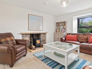 a living room with two couches and a fireplace at Morfa Ganol in Llangranog