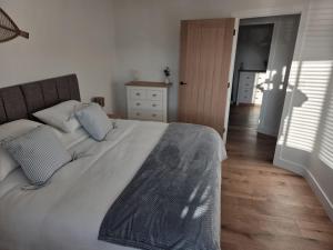Un dormitorio con una cama grande y suelo de madera. en Little Fairacre - Two double bedroom annexe, en Braunton