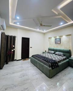een slaapkamer met een groen bed en een plafond bij Luxury home in Multan in Multan