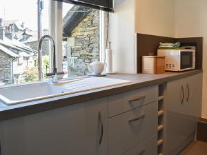 a kitchen counter with a sink and a window at Upper Sycamore Cottage in Ambleside +12 photos