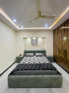 een slaapkamer met een groot bed en een plafond bij Luxury home in Multan in Multan