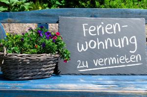 a sign sitting on a bench with a basket of flowers at Leonardo Loft - Exklusiv, WLAN, Erdgeschoss, 15 Minuten vom Europa Park in Malterdingen