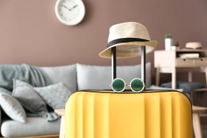 a hat and sunglasses on top of a yellow suitcase at Leonardo Loft - Exklusiv, WLAN, Erdgeschoss, 15 Minuten vom Europa Park in Malterdingen